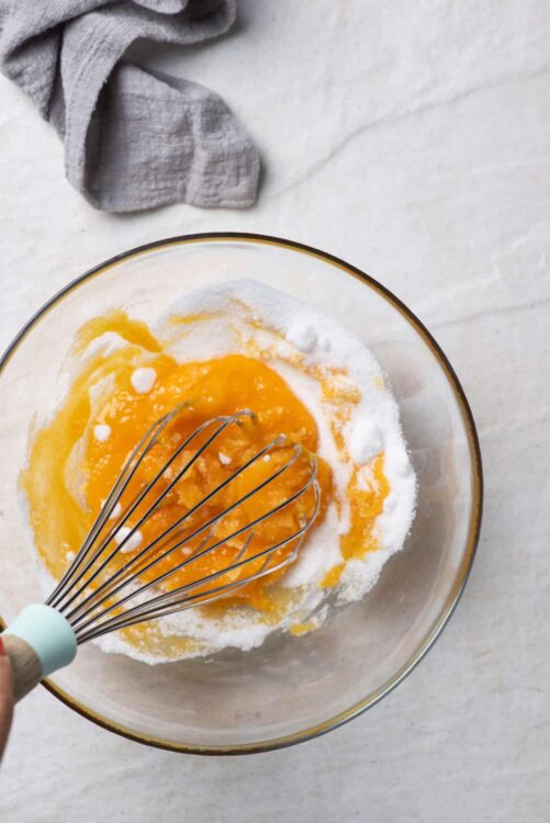 Flour, sugar, and eggs in a mixing bowl for baking or cake preparation.