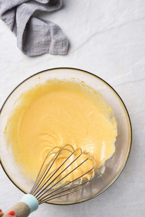 Whisking eggs in a glass bowl for baking or cooking.