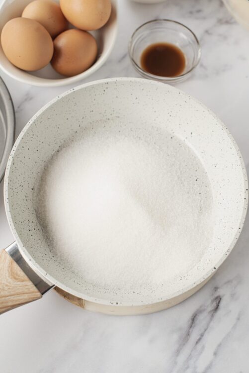 Flour in a white speckled mixing bowl for baking bread or pastries.