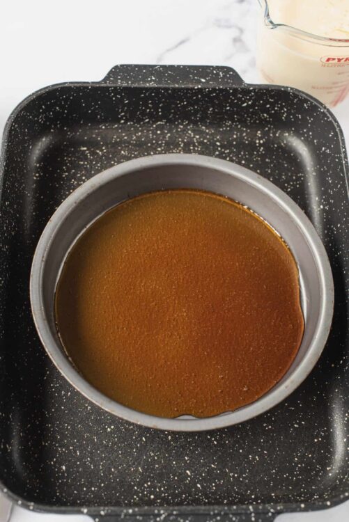 Golden caramel sauce melting in a saucepan on a stovetop.