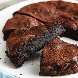 Decadent homemade chocolate lava cake with a gooey center on a white plate. Perfect for dessert lovers and chocolate enthusiasts.