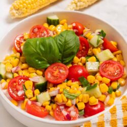 Fresh corn salad with cherry tomatoes, cucumbers, red onions, and basil. Perfect for summer meals and healthy snacking.