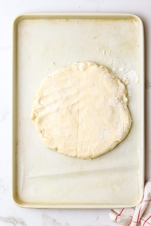 Buttery pie dough resting on a baking sheet for homemade baking recipes.