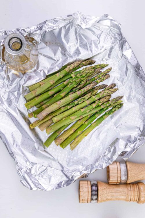 Fresh green asparagus spears wrapped in foil for roasting or grilling. Perfect for healthy vegetable dishes.