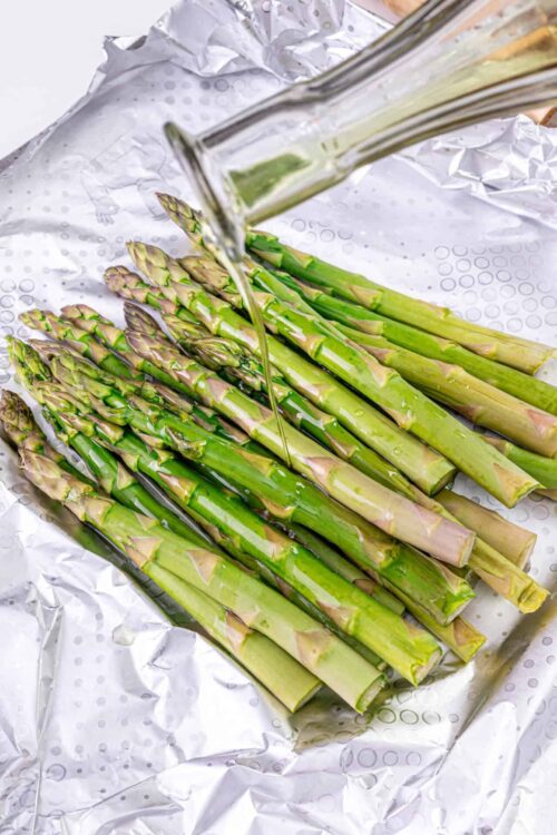 Fresh asparagus being prepared for baking or roasting.