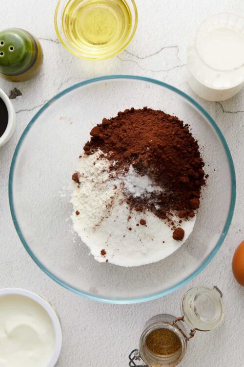 All-purpose flour, cocoa powder, sugar, and baking ingredients in a mixing bowl for baking.