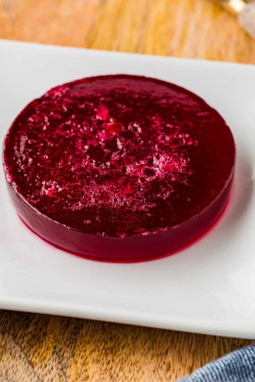 Fresh homemade berry gelatin dessert on a white plate.