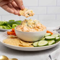 Creamy cheese dip with blue cheese crumbles, served with fresh vegetables and crackers.