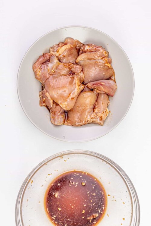 Marinated raw chicken thighs with garlic and soy sauce mixture.