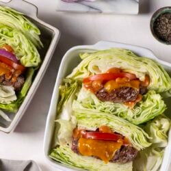 Fresh lettuce wraps with beef, cheese, and vegetables on a white plate.