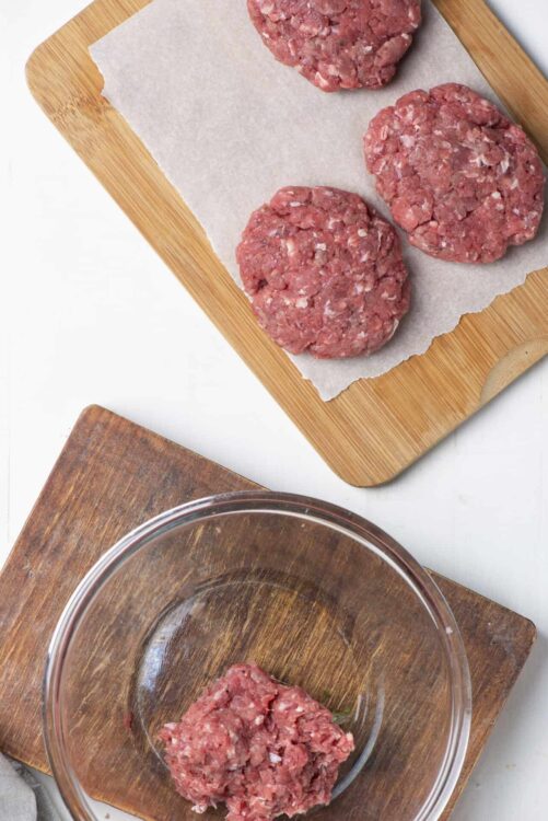Ground beef meatballs on a wooden cutting board.