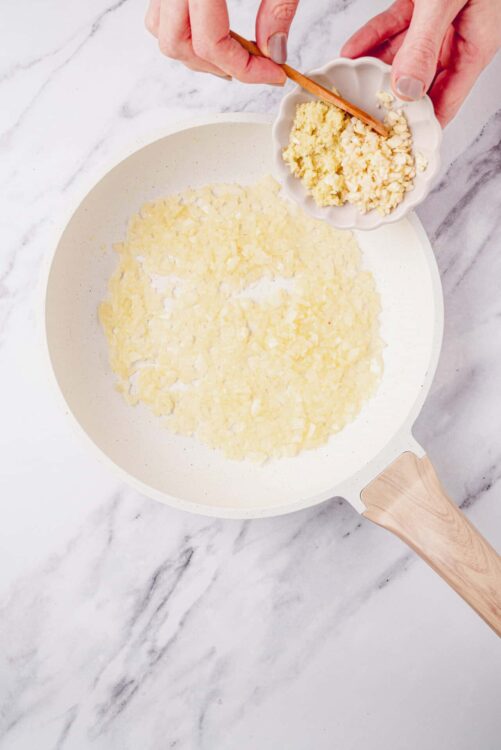 Finely chopped white chocolate melting on a peanut butter skillet for baking desserts.