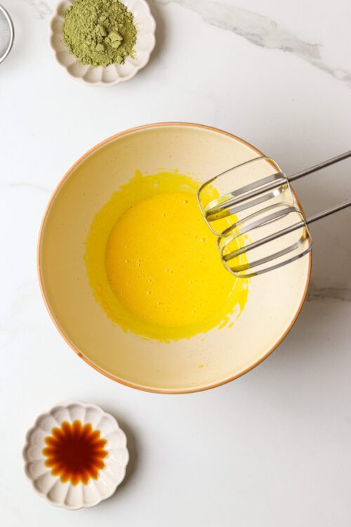 Creamy yellow egg mixture in mixing bowl, baking ingredients for cake batter, baking with fresh eggs.