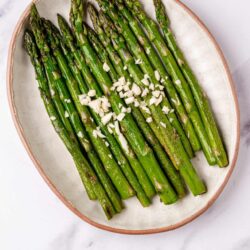 Roasted asparagus with garlic in baking dish.