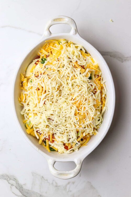 Shredded cheese casserole in a white baking dish for cheesy baked recipes.