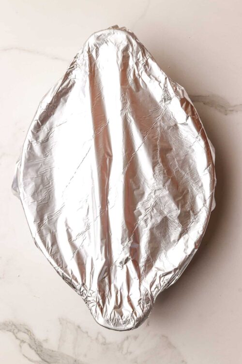 Aluminum foil-wrapped dish for baking or roasting, ready to be cooked or stored.
