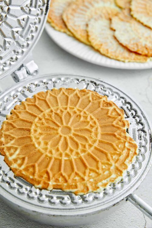 Golden honeycomb waffle on a vintage glass cake stand, perfect for breakfast or brunch.