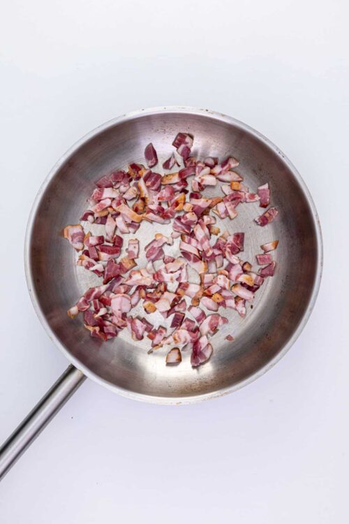 Crispy cooked bacon in a stainless steel skillet for breakfast or recipe.