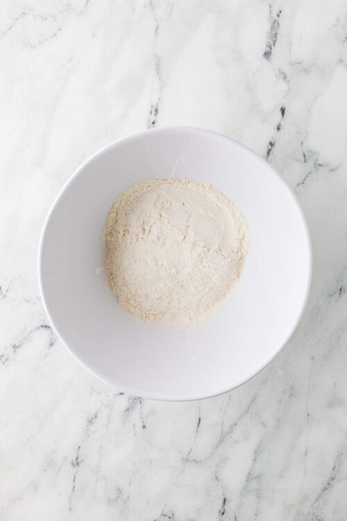 Creamy fresh mozzarella cheese in a white bowl for homemade pizza or caprese salad preparation.