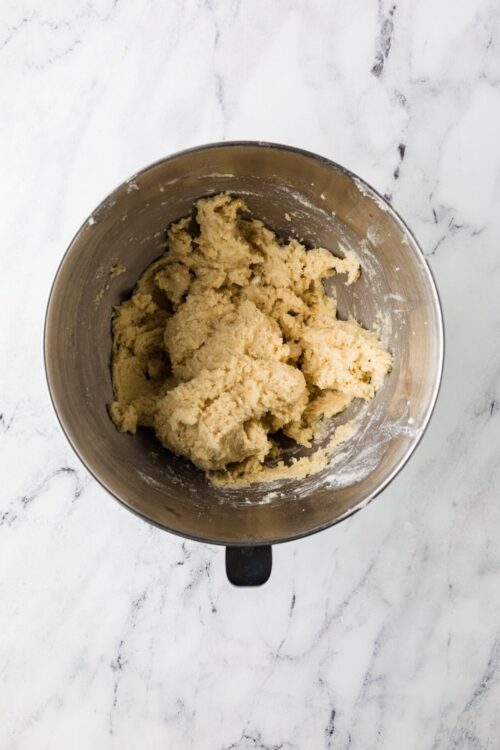 Crumbly cookie dough in a mixing bowl.