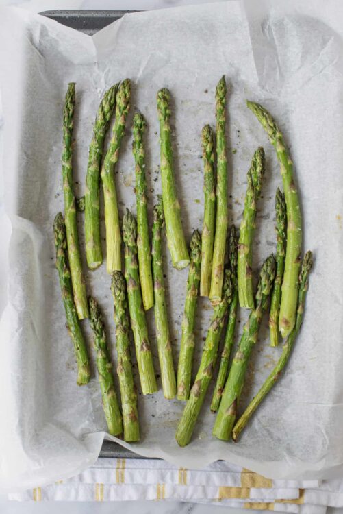Fresh roasted asparagus spears on parchment paper.