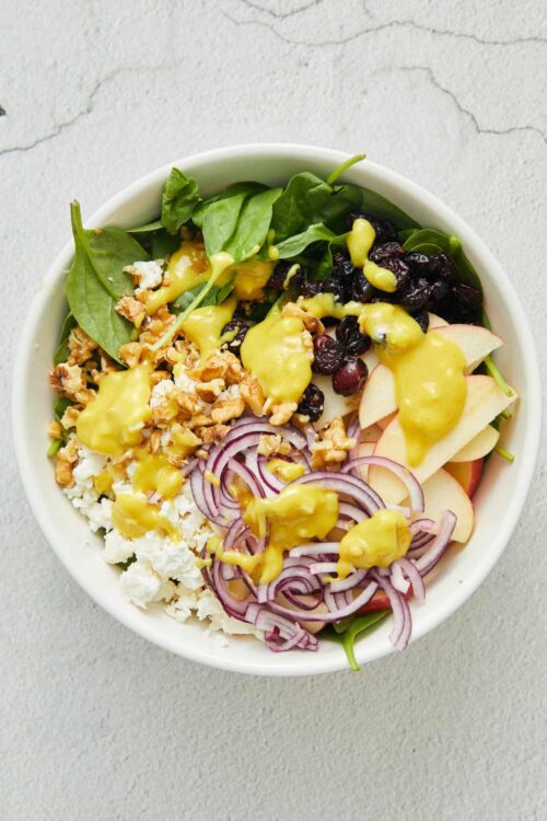 Fresh mixed salad with spinach, blueberries, apple slices, feta cheese, walnuts, red onion, and honey mustard dressing.