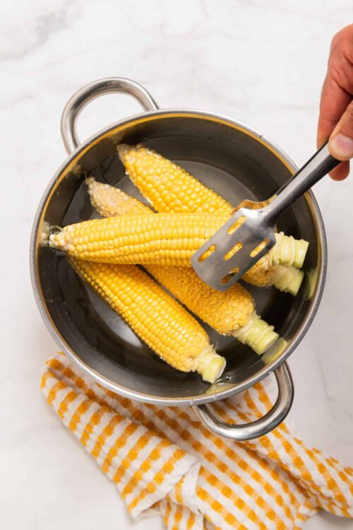 Sweet corn on the cob boiling in a pot, ready for cooking or serving.