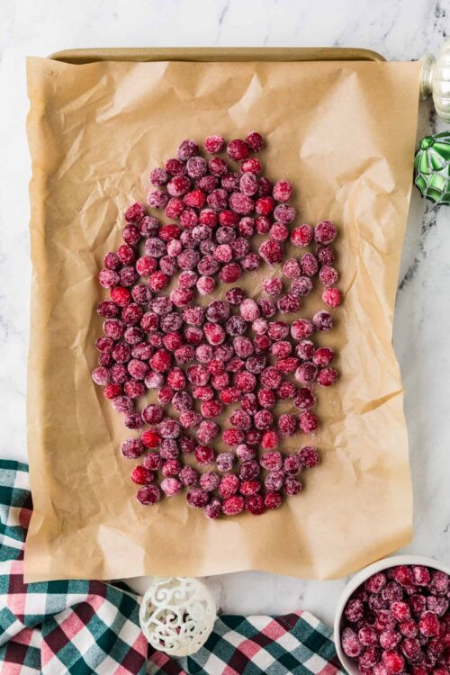 Frozen cranberries on parchment paper for baking.