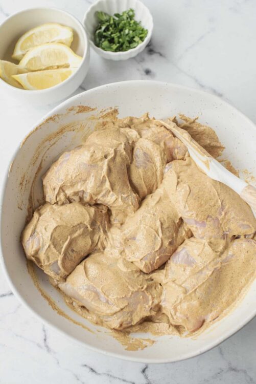 Marinated chicken breasts in a creamy spice sauce, ready for baking or grilling. Perfect for flavorful dinner recipes.