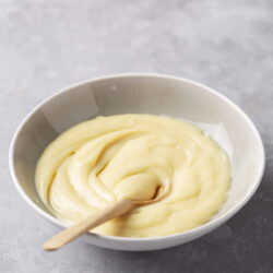 Creamy vanilla custard in a ceramic bowl, ready for baking or dessert.