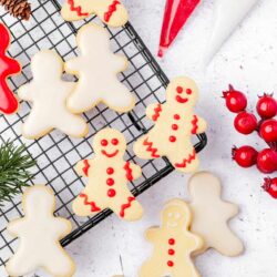 Cute gingerbread cookies decorated with red icing on cooling rack for holiday baking.