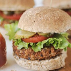 Crispy vegan chickpea burger with fresh vegetables and whole wheat bun.