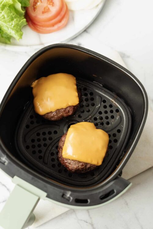 Crispy cheeseburgers in air fryer, cheeseburgers with melted cheddar, easy air fryer cheeseburgers, flavorful homemade cheeseburgers, quick air fryer burger recipes.