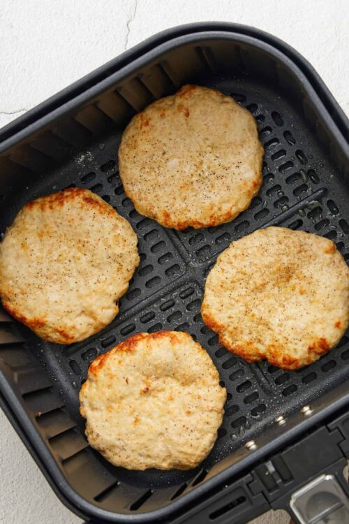 Golden baked chicken breasts in air fryer, seasoned and crispy.