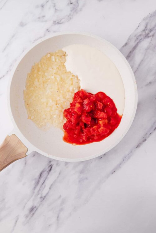 Cream cheese, shredded coconut, and cherry compote in a white skillet on marble surface.