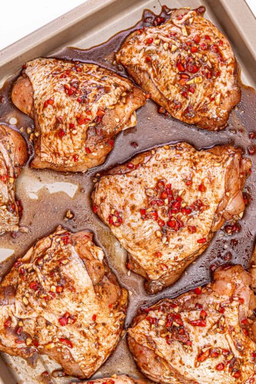 Juicy baked chicken thighs topped with chopped red chili and garlic, glazed in a savory sauce.
