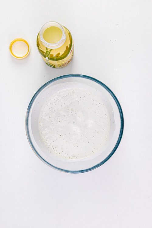Flaxseed egg substitute in a glass bowl on a white surface, with flaxseed meal and water. Perfect for vegan baking recipes.