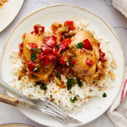 Savory baked chicken thighs with peppers and herbs served over fluffy white rice. Perfect comfort food recipe from Baked Bree.