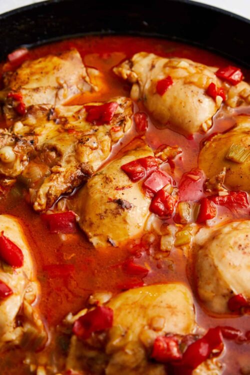 Juicy baked chicken thighs with tomatoes and peppers in a flavorful sauce.