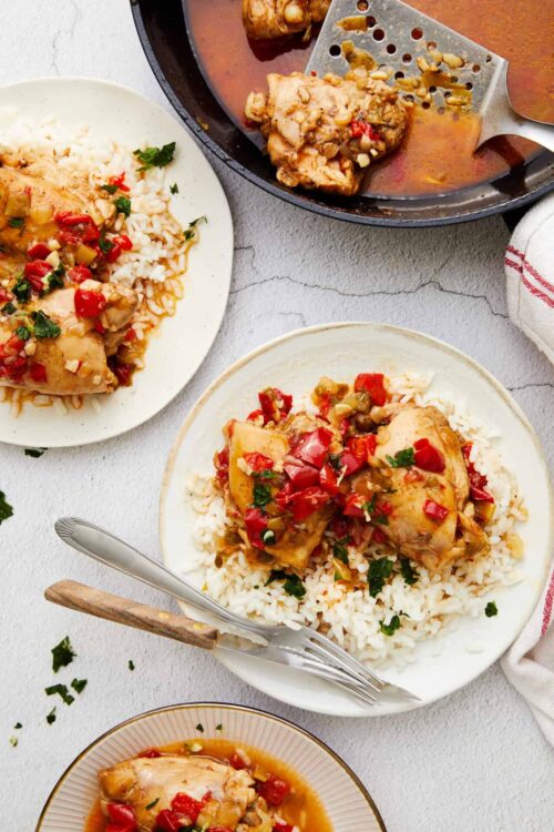Juicy chicken thighs with tomato-based sauce served over rice, homemade comfort food recipe.