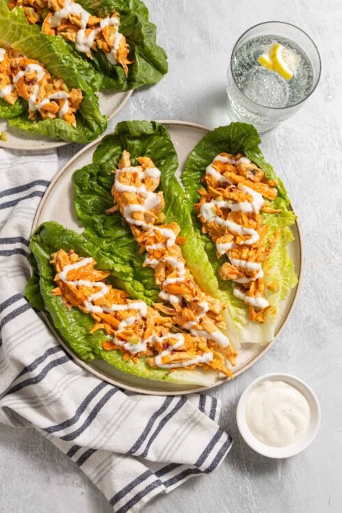 Grilled chicken lettuce wraps with creamy dressing and fresh lemon water. Healthy and flavorful lettuce wraps for a light meal.