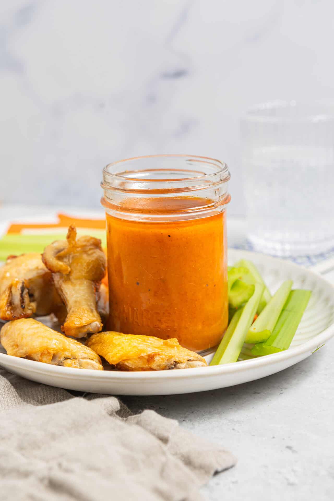 Savory chicken wings with spicy dipping sauce on a white plate.