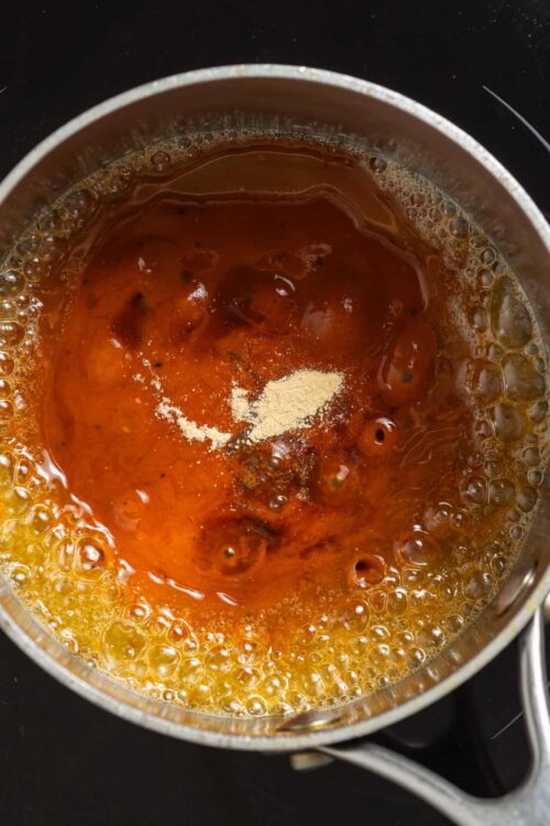 Sweetened condensed milk bubbling in a saucepan for baking recipes.