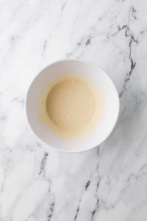 Creamy batter in a white bowl for baking or dessert recipes.