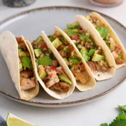 Fresh grilled chicken tacos with avocado, cilantro, and tomato salsa on soft flour tortillas.