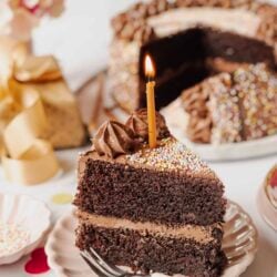 Delicious chocolate birthday cake with a lit candle and colorful sprinkles, perfect for celebrations.