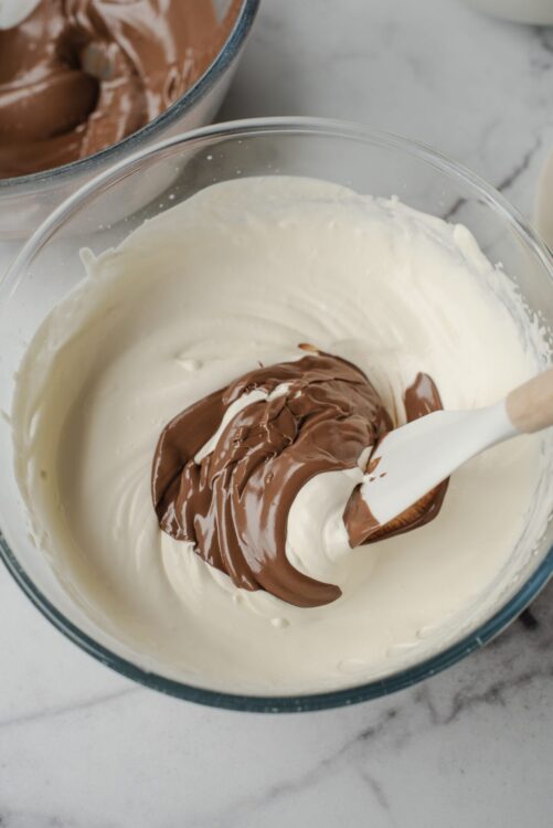 Silky vanilla and chocolate mousse mixed in glass bowl for dessert.