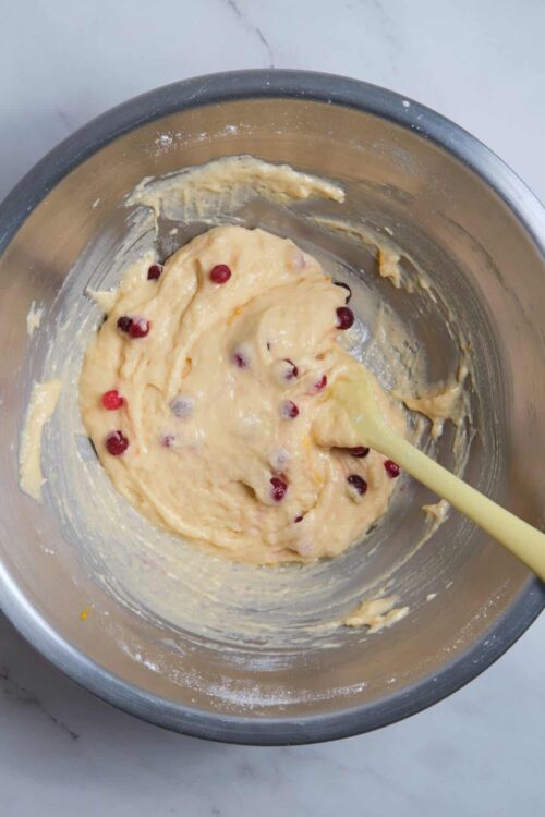 Fresh berry muffin batter in a stainless steel mixing bowl.