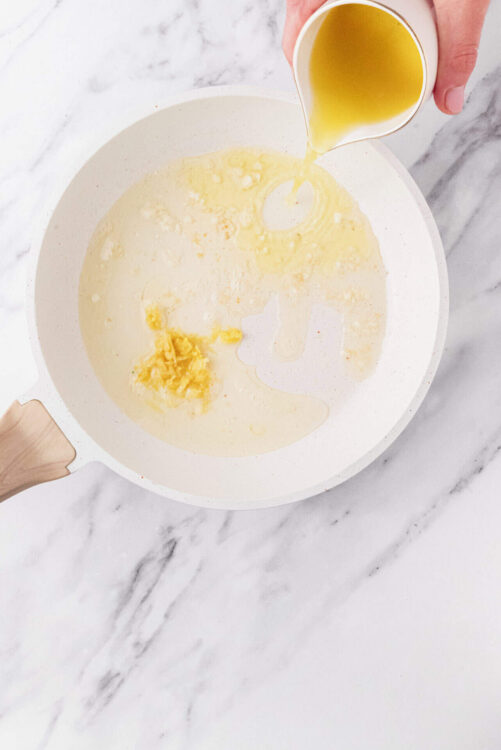 Cream and melted butter in a white skillet for baking recipes.