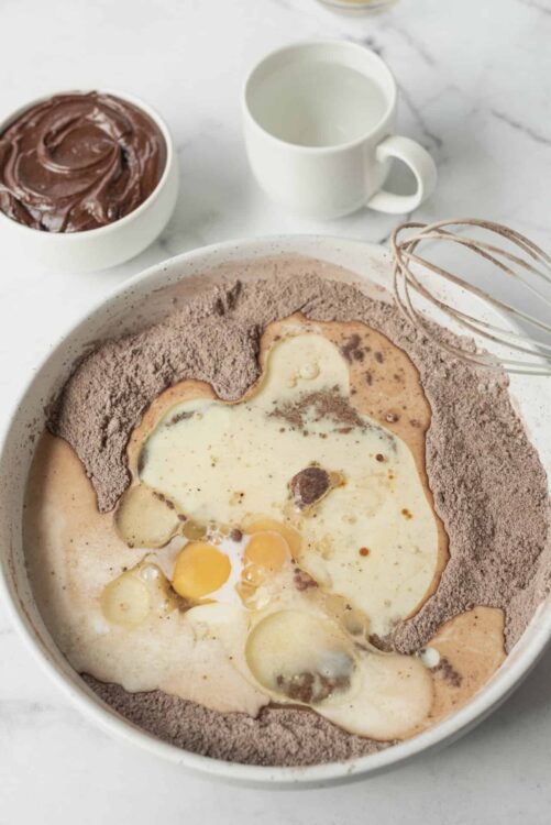 Flour, eggs, and chocolate mixture in a baking bowl for baking recipes.